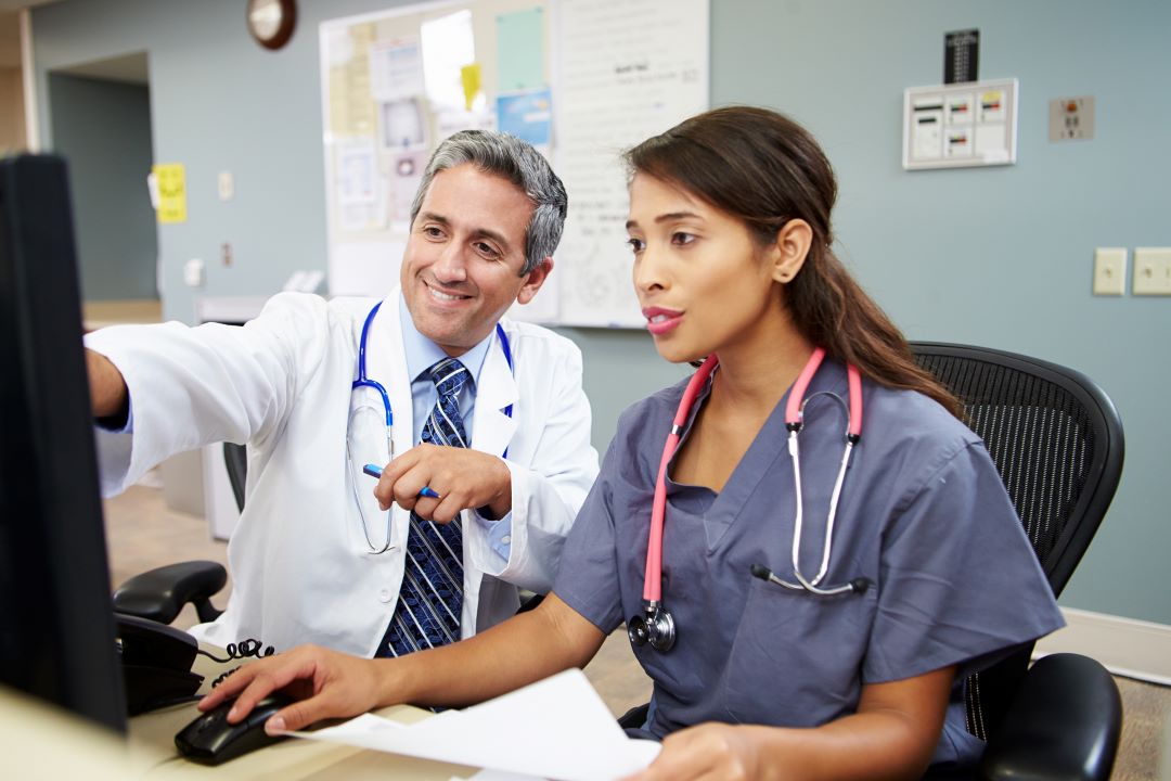 Doctor and staff member looking at computer