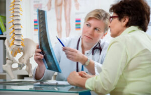 Doctor with spine X-ray and patient